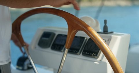 Close-up of a Skipper Holding Sailing Yacht's Steering Wheel. Dashboard Shows Knots, Degrees and Wind Direction. Calm Sea in the Background. Shot on RED Epic 4K UHD Camera.