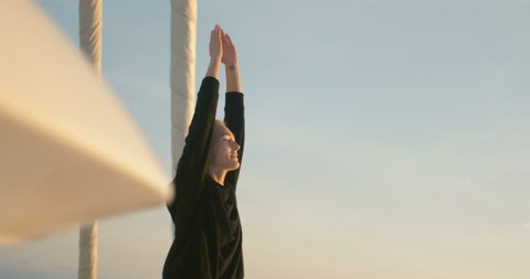 Close-up Shot of a Fit Young Woman Doing Yoga on a Sailing Yacht. In the Background Beautiful Calm Sea and Clear Sunny Sky. Shot on RED Epic 4K UHD Camera.
