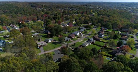 A daytime forward aerial establishing shot of a typical western Pennsylvania residential neighborhood in the early autumn.  	Pittsburgh suburbs.