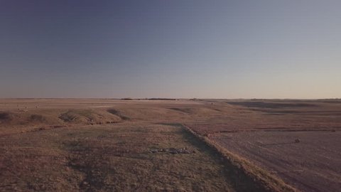 aerial drone footage of North Dakota prairie pasture land as the sun sets
