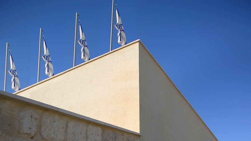 Four flags of Israel flapping in wind at top of the building