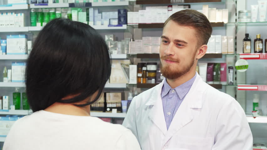 The pharmacist and his client are in the pharmacy. They have a sweet talk. Then the pharmacist gives the woman a bag with her purchases. He slaps her friendly on the shoulder Royalty-Free Stock Footage #32221126