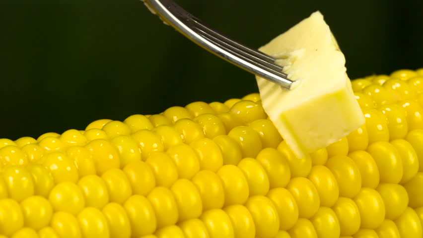 A piece of butter strung on a fork slowly moves along the surface of hot co...