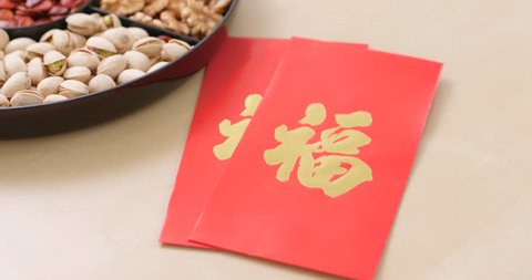 Chinese new year assorted snack tray with red pocket, red packet with a chinese word meaning luck 库存视频