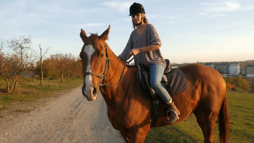 Young woman riding a horse in the countryside. Equestrian sport