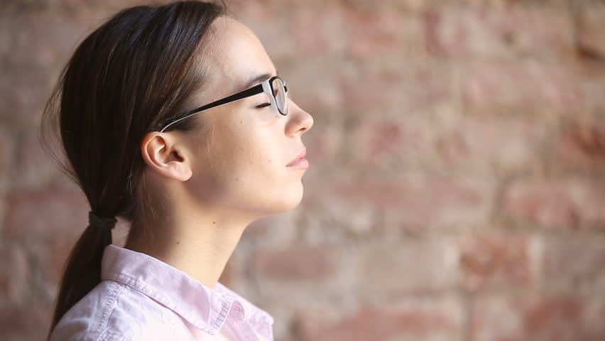 Young woman wearing glasses inhaling and exhaling fresh air, taking deep breath, enjoying practicing breathing pranayama exercises indoors, calming down, reducing stress, close up face side view | Shutterstock HD Video #32239261