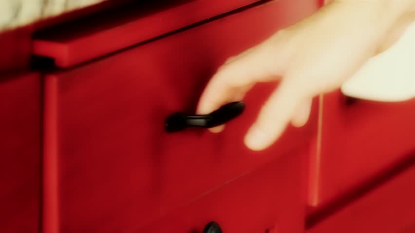 A hand opens a kitchen drawer