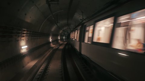 View of subway tunnel as seen from reverse of moving backward train. Fast underground train riding in tunnel of modern city. Long footage of underground train in Barcelona following its route