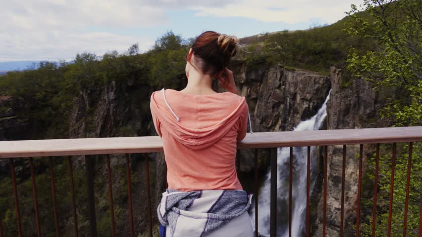 Woman looking at Seljalandsfoss watfall in Iceland