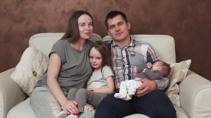 Happy family with children sitting on sofa at home