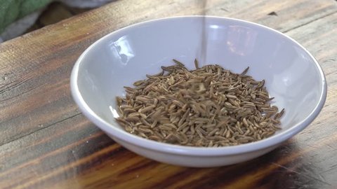 Pouring caraway seeds into a spice dish