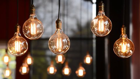 Decorative antique edison style filament light bulbs hanging on ceiling, lamp decoration in shop, electric light, incandescent lamp, hot spiral of tungsten bulb.