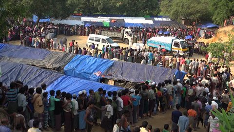 TEKNAF, BANGLADESH - OCTOBER 25, 2017: A long queue of Rohingya refugees who have escaped Myanmar into Bangladesh, are standing and waiting in a long line for the food emergency relief distribution