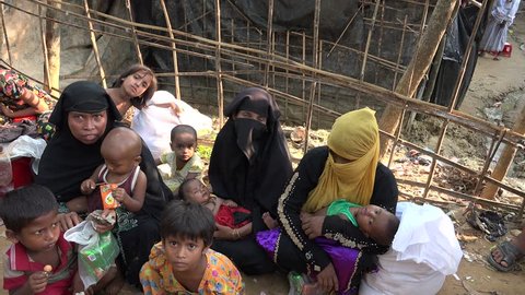 TEKNAF, BANGLADESH - OCTOBER 25, 2017: A group of women, some of them in burqa and niqab, sit together in the Rohingya refugee camp in Bangladesh