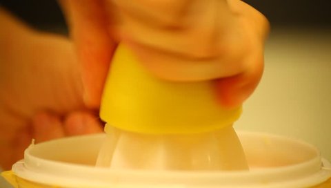 Young adult woman squeezes lemon. Kitchen interior shot.
 Stockvideó