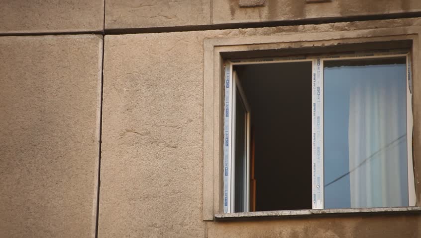 Young adult woman drinks coffee to the window. Eastern Europe, Bucharest, Romania.
