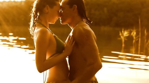 Romantic young couple in lake kissing, embracing