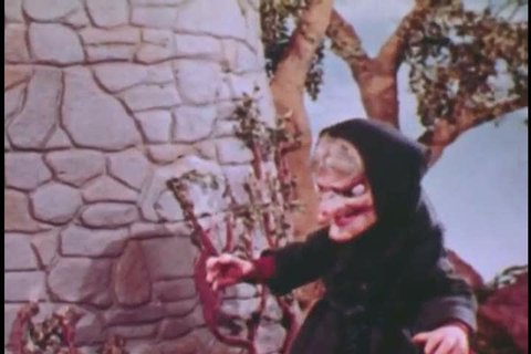 CIRCA 1950s - Rapunzel, imprisoned in a tower, grows her hair into a rope ladder and witch climbs it, in an animated fairy tale, in 1951.