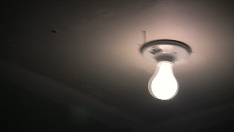 Rustic basement light flickering during an earthquake, shot in HD 1080i.