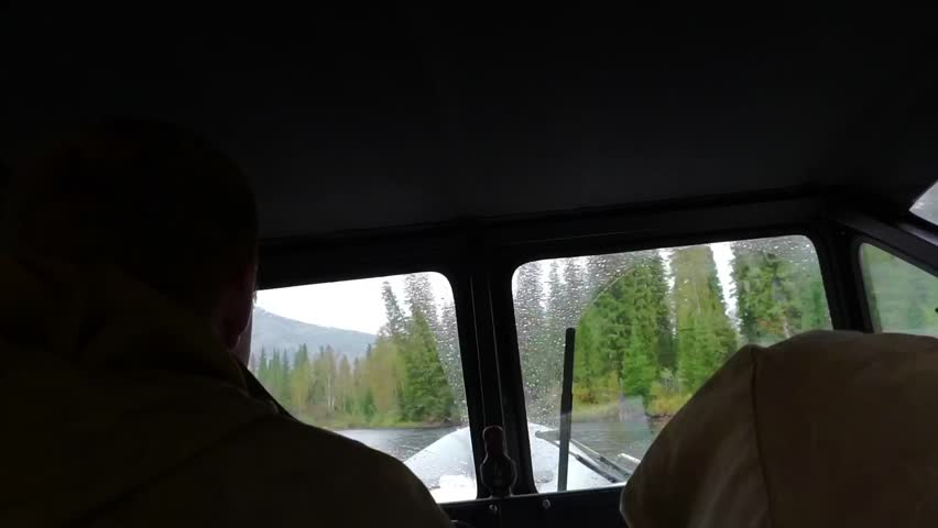 Moving by the taiga river behing unindentified men back inside airboat