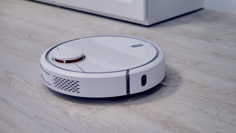 Detailed view on a self-moving robotic vacuum on the floor.    