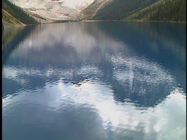 Flying low over Lake Gloria with reflections in Banff National Park Canada