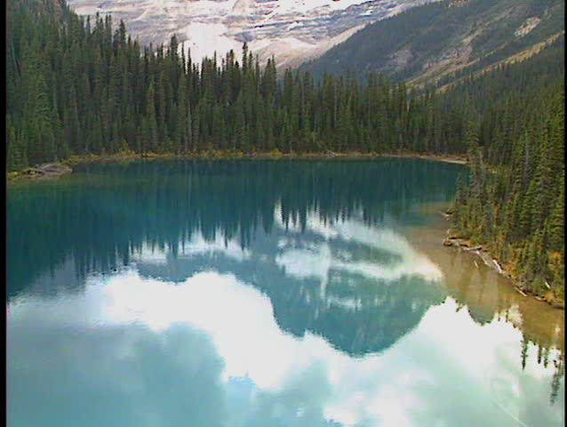 Flying low over Lake Gloria with reflections in Banff National Park Canada