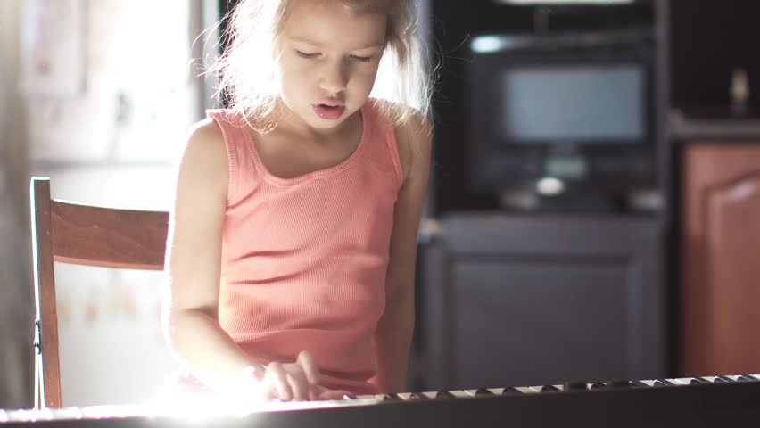 little girl 6 years learning to play the piano. the child rehearses a piece of music Royalty-Free Stock Footage #32286133