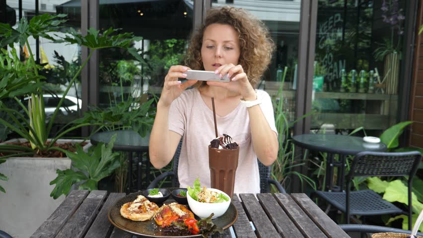 Young Woman Taking Picture Of Food In Outdoor Cafe With Smartphone. 4K. 