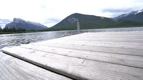 Low angle view of young woman walking barefoot on wooden pier above mountain lake in Canada. People travel concept
Shot in Banff national park in Canada