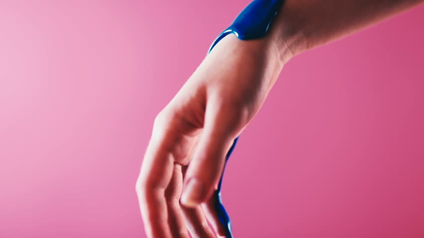 Blue paint flows down on the arm close up