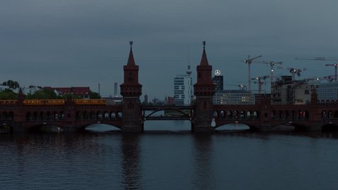 May, 2017 Berlin, Germany. Aerial drone push in on Oberbaum bridge with S-bahn train ascends and reveals Berlin Skyline with Spree river and TV Tower.