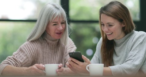 Senior woman and daughter looking at a smartphone