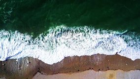 Drone video of ocean water and waves at beautiful beach and sand in summer, aerial horizontal moving footage