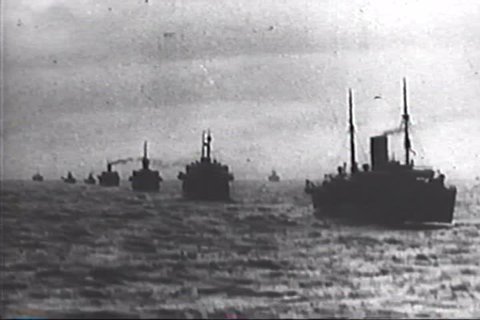 CIRCA 1940s - Merchant ships, protected by warships, arrive with cargo, including an armored vehicle and a tank, during the Battle of Tunisia, in World War 2, in 1943.