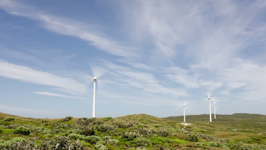 Time lapse of Windmills/ Wind Turbines set against cloudy blue skies at the
