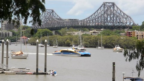 BRISBANE, AUSTRALIA - January 7 2013: City Cat passes by the Story Bridge. A tourist attraction, the city cat ferry service began in 1996 and has 13 vessels that are named after aboriginal places. 

