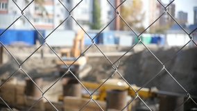 Construction grid in focus, with a blurred background of construction in the background. HD, 1920x1080. slow motion.