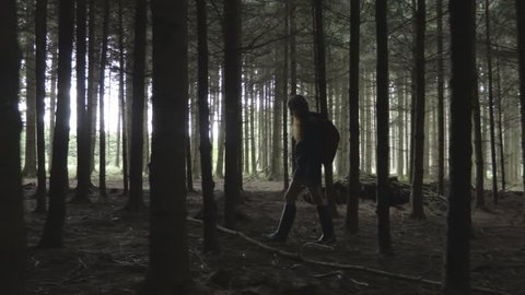 Young woman walk slowly through the trees in the forest