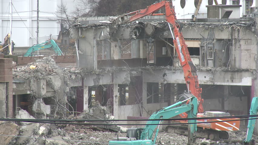 Japan Tsunami 1 Year On - Demolishing Damaged Building. Construction equipment