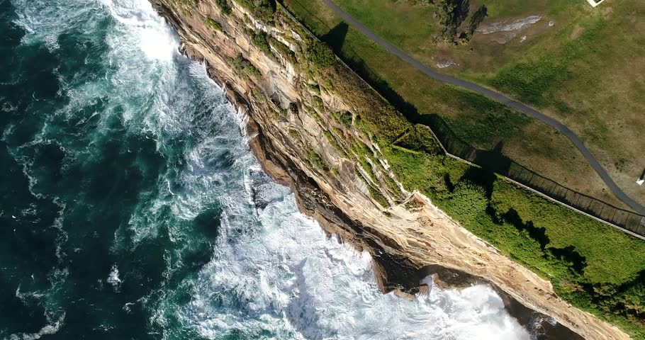 Steep sandstone cliff of Sydney Eastern suburbs facing pacific ocean with endless waves breaking and undermining the coast.
 Royalty-Free Stock Footage #32322304