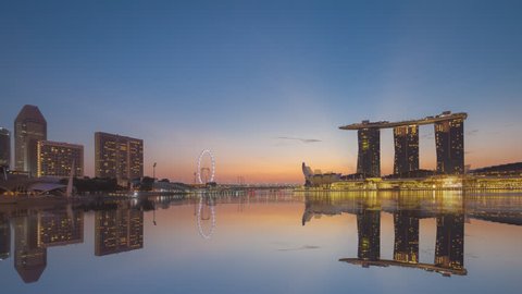 Beautiful Time lapse of Night to Day of Singapore skyline with beautiful reflection. 4K UHD.