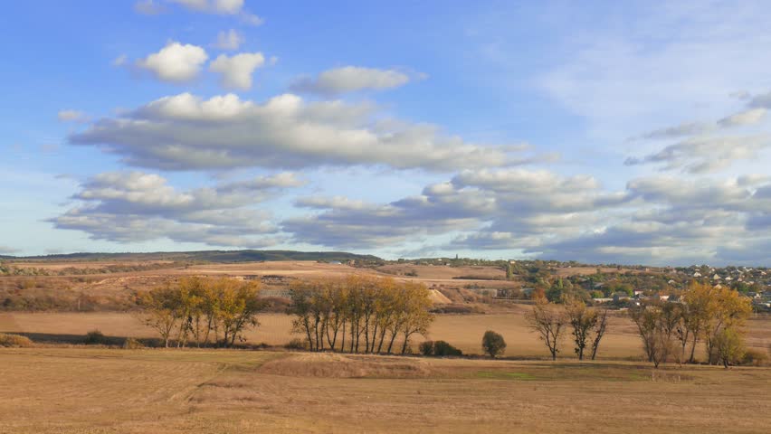 Landscape of countryside with white clouds in blue sky in autumn sunny day / Autumn landscape of village outskirts
