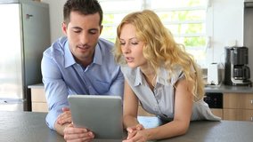 Young couple websurfing with tablet in home kitchen