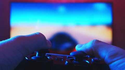 Close view of a gamer's hands playing racing video game on his console using joystick Video de stock