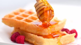 Waffles with honey and berries close-up. Healthy breakfast. Honey pouring on a fresh Belgian waffles.