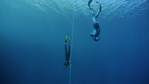 Freediver instructor follows student freediver during dive. Blue Hole, Dahab, Egypt.