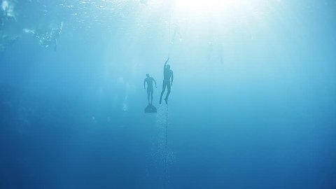 Freedivers ascend along the rope in a sea. Blue Hole, Dahab, Egypt.