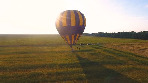People walking around wicker basket of air balloon landed in field, destination 库存视频