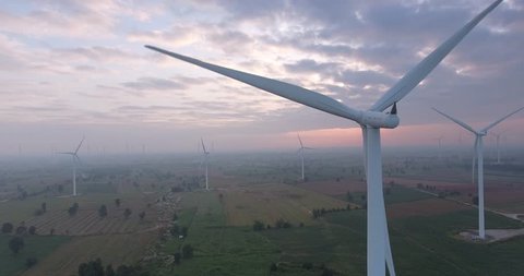 Aerial view of  Wind turbines Energy Production- 4k aerial shot on sunset. 4k drone footage turbines at sunrise with clouds